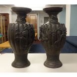 An impressive pair of large Chinese or Japanese bronze vases, each decorated in relief with stylised