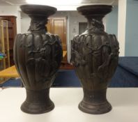 An impressive pair of large Chinese or Japanese bronze vases, each decorated in relief with stylised