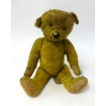 An early 20th Century German teddy bear with hump back and glass eyes, height 47cm circa 1920/30.