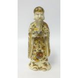 A Chinese porcelain figure of a man with long beard, gilt decorated cloak and hat