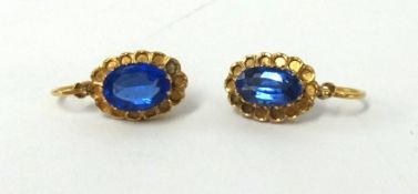 A pair of sapphire style and yellow metal earrings.