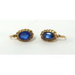 A pair of sapphire style and yellow metal earrings.