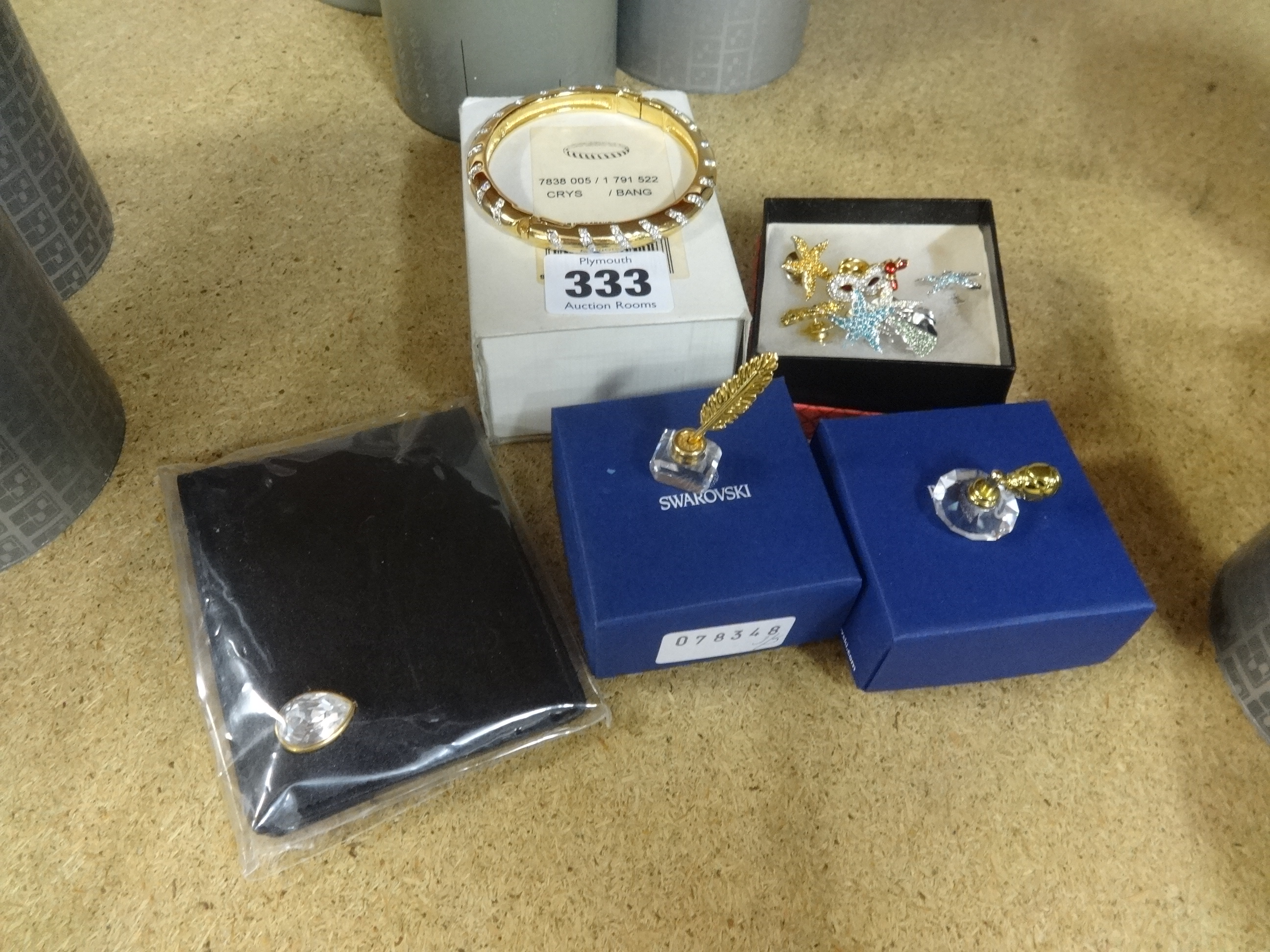 Swarovski, crystal bangle, inkwell and pen, scent bottle, wallet and seven pin brooches, boxed.