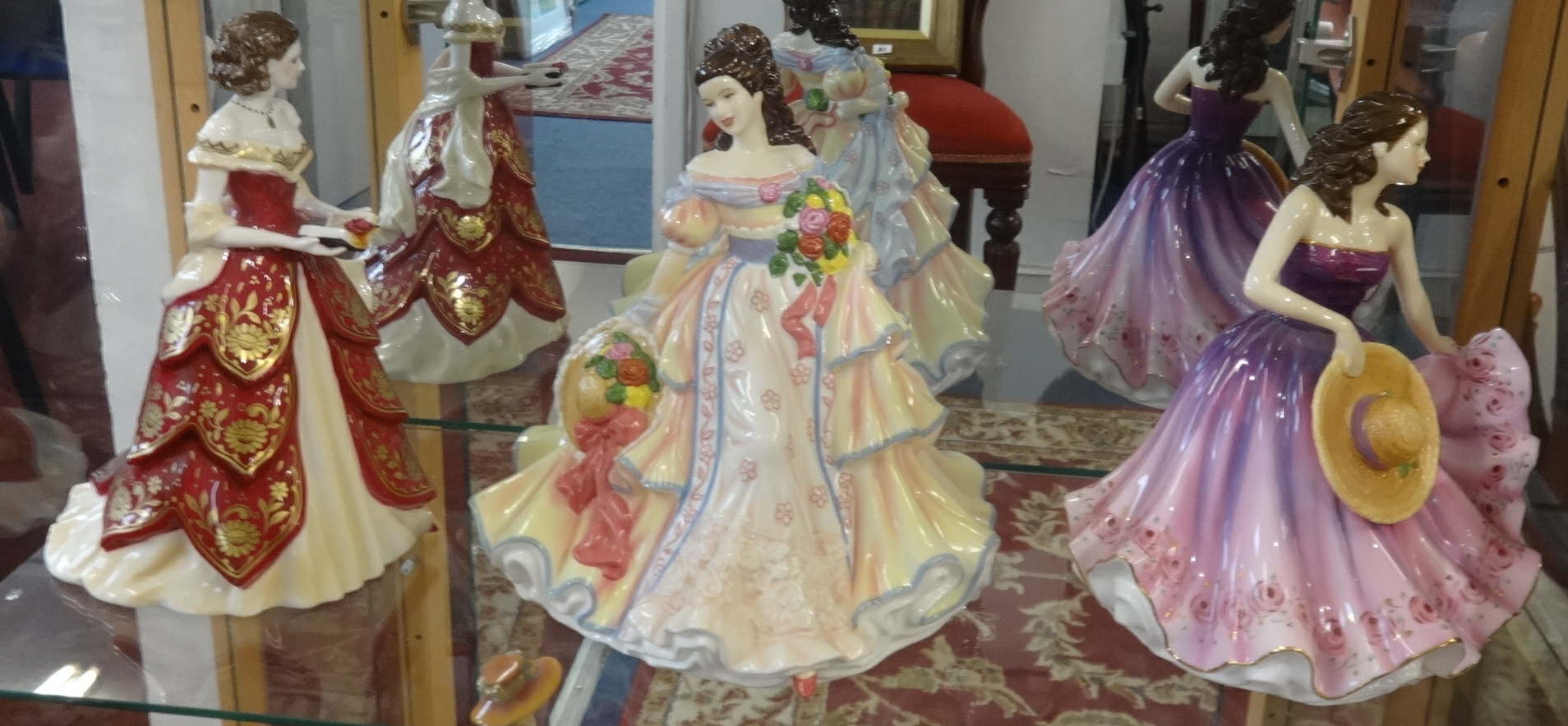 A collection of 19 porcelain figurines including Coalport, Doulton Pretty Ladies series and