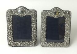 A pair of silver photo frames with embossed scroll work decoration glazed, approx. 21cm x 15cm