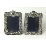 A pair of silver photo frames with embossed scroll work decoration glazed, approx. 21cm x 15cm