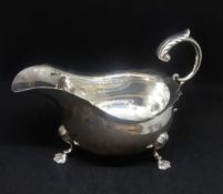 George V silver sauce boat with scallop edge and paw feet with acanthus scroll handle, Walker & Hall