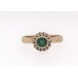 An 18ct emerald and diamond cluster ring, finger size M.