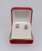 A pair of princess cut diamond stud earrings each of square form set with nine stones in yellow