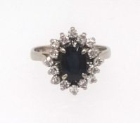 An 18ct white gold sapphire and diamond cluster ring, finger size L.