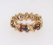 An 18ct sapphire and ruby contemporary band ring, finger size N/O, approx. 6.5gms.