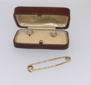 An 18ct bar brooch (3.7gms) together with a pair of 18ct gold dress studs set with a diamond and