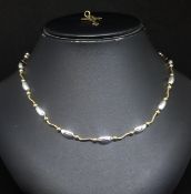 A 9ct yellow and white gold necklace set with oval and curved sections (approx. 14.5gms) new in 2009
