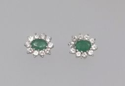 A pair of emerald and diamond effect cluster earrings.