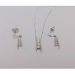 A modern 9ct white gold and diamond contemporary pendant and matching earrings.