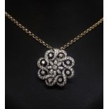 A diamond set swirl combination pendant brooch set in white metal and a 9ct yellow gold chain and