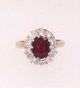 A ruby and diamond cluster ring set in yellow gold, finger size J.