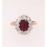 A ruby and diamond cluster ring set in yellow gold, finger size J.