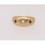 An 18ct gypsy style three stone sapphire and diamond ring, finger size F.