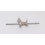 A brooch surmounted with West Highland Scottie set with diamonds, the brooch stamped 15 and 18ct