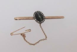 An antique 9ct gold bar brooch set with hardstone and diamond cluster.