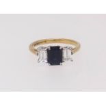 An 18ct sapphire and diamond three stone ring the centre stone rectangular flanked by a pair of