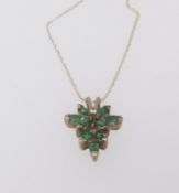 A modern 9ct emerald, gold and diamond drop pendant.