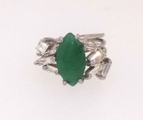 An emerald and diamond ring set with baguette and square cut diamonds set in unmarked white metal,