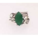 An emerald and diamond ring set with baguette and square cut diamonds set in unmarked white metal,