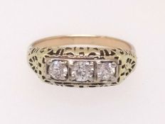 A diamond three stone ring set in unmarked yellow metal, finger size N/O.