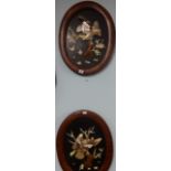 A pair of Japanese oval wall plaques lacquered, decorated in relief with birds, 55cm x 41cm.