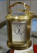 A French miniature oval brass carriage clock, the dial marked 'L'epee' with key, height 11cm, handle