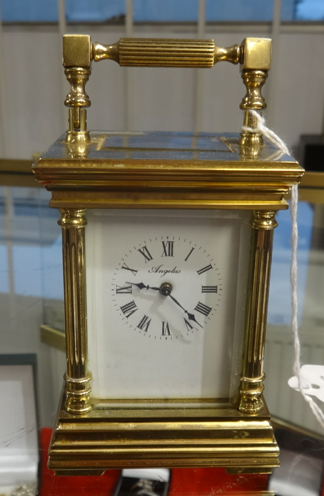 A French carriage clock and key, the dial marked 'Angelus', height 11cm, handle up.