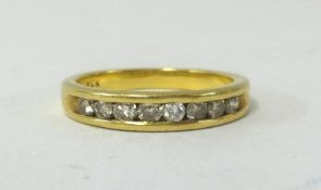 A foreign yellow gold diamond channel half eternity ring, set with brilliant cut diamonds, approx