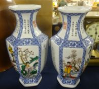 A pair of modern oriental porcelain vases with decorated panels of figures and script, height 30cm.