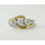 An 18ct white and yellow gold three stone diamond ring, stamped 750.