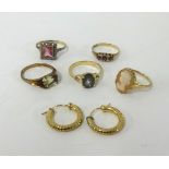 A collection of five dress rings and a pair of gold earrings.