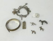 A silver charm bracelet and other silver objects together with a silver bangle.