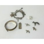 A silver charm bracelet and other silver objects together with a silver bangle.