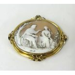 An antique cameo set in unmarked yellow metal carved with a romantic scene.