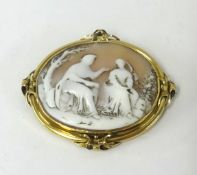 An antique cameo set in unmarked yellow metal carved with a romantic scene.