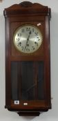 A mahogany cased wall clock with eight day chiming movement.