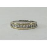 An 18ct white gold and channel set half band diamond eternity ring, finger size M.