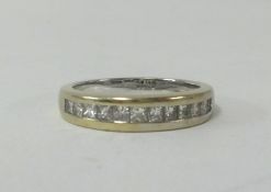 An 18ct white gold and channel set half band diamond eternity ring, finger size M.