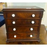 A 19th Century apprentice type miniature chest fitted with four drawers, height 29cm, width 29cm.