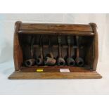 OAK PIPE STAND WITH TAMBOUR FRONT AND CONTENTS OF WOODEN PIPES