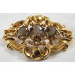 Large 9 carat gold scrolled oval brooch set with three smoked glass stones, (overall 38mm x 54mm),