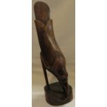 A finely carved figure of a bird with elongated tail eating lizard, perhaps Polynesian, height 28cm