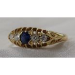 18 carat gold ring set with a central sapphire (diameter about 3mm) between two pairs of diamonds (