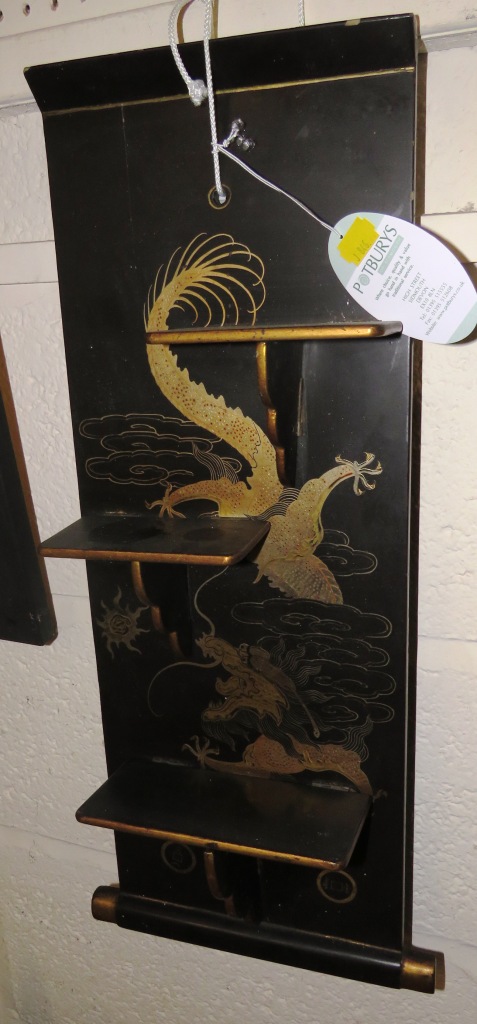 A WALL-HANGING BRACKET WITH THREE FOLDING SHELVES, BLACK LACQUER WITH GILT AND ENAMEL CHINESE DRAGON